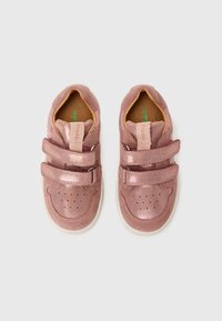 Scarpe di pelle rosa con due fasce in velcro, punta arrotondata, dettagli perforati e suola in gomma bianca. Texture morbida, design minimalista.