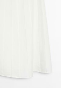 Tissu blanc avec des plis verticaux cousus, tombant droit avec une texture lisse et de légères ondulations près du bord inférieur.