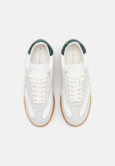 White and gray leather sneakers with a green heel counter, featuring cream laces, gold logo detailing, and brown rubber soles.