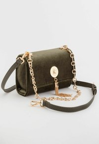 Oliven grøn velour crossbody taske med en guld kæde og frynse accent, som har en dekorativ guldlås og en aftagelig læderrem.