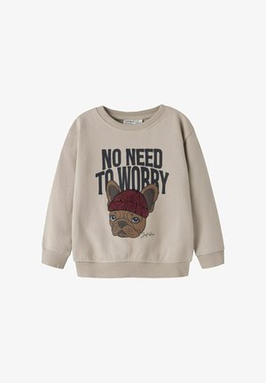 Sweat-shirt beige présentant un bulldog français en dessin animé portant un bonnet rouge, avec le texte "PAS BESOIN DE S'INQUIÉTER" au-dessus.