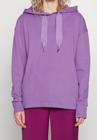 Sudadera morada de mezcla de algodón, con bolsillo tipo canguro, capucha con cordón y acentos de logo, y puños y dobladillo acanalados.