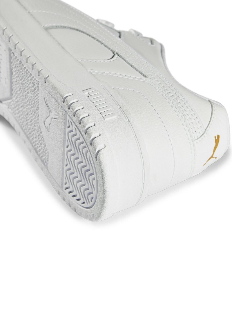Białe sneakersy wykonane ze skóry, z teksturowanymi akcentami, złotym logo i wzorzystą gumową podeszwą. Widoczne charakterystyczne przeszycia.