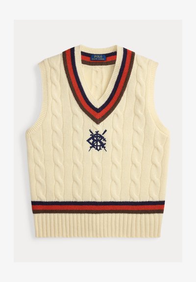 Kreem värviline kootud vest, millel on ketramustrid, V-kaelus ja mitmevärvilised triibud (punane, tumesinine, pruun) kaela ja heml. Omab broderitud logo.