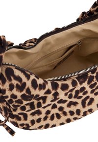 Handtas in luipaardprint met een stoffen buitenkant, ritssluiting en een beige interieur met een klein ritsvak en een zachte textuur.