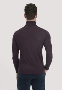 Dunkel-lila Rollkragenpullover aus weichem Material, mit langen Ärmeln und Rippdetails am Kragen und Saum.