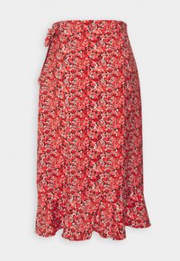 Jupe portefeuille florale rouge avec accents noirs. Tissu léger présentant un ourlet à volants et de petits motifs floraux vibrants sur l'ensemble.