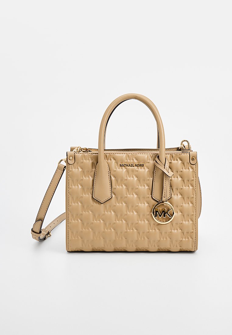 Sac à main en cuir beige avec motif logo MK en relief, doubles poignées supérieures, bandoulière amovible et accents en métal doré.