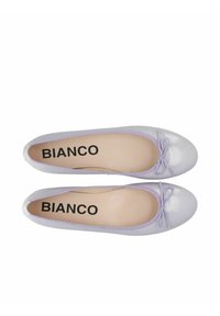 Ballerines lilas avec une finition brillante, bout arrondi et un petit nœud décoratif. Elles disposent d'une doublure intérieure douce et d'une semelle plate.