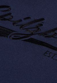 Navy blue sweatshirt with a soft texture, featuring a black velvet logo design and the text "EST" in a contrasting font below.