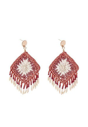 Pendientes de ganchillo en forma de diamante rojos con un diseño floral blanco, adornados con cuentas blancas y burdeos, con un herraje dorado en la parte superior.