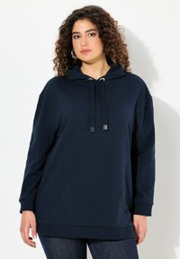 Felpa blu navy realizzata in tessuto morbido, con tasca a marsupio, cappuccio con coulisse e polsini a coste. Vestibilità ampia e maniche lunghe.