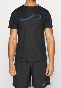 Sort atletisk t-shirt lavet af glat stof, med et blåt prikket uendelighedssymbol på forsiden. Matcher med sorte shorts.