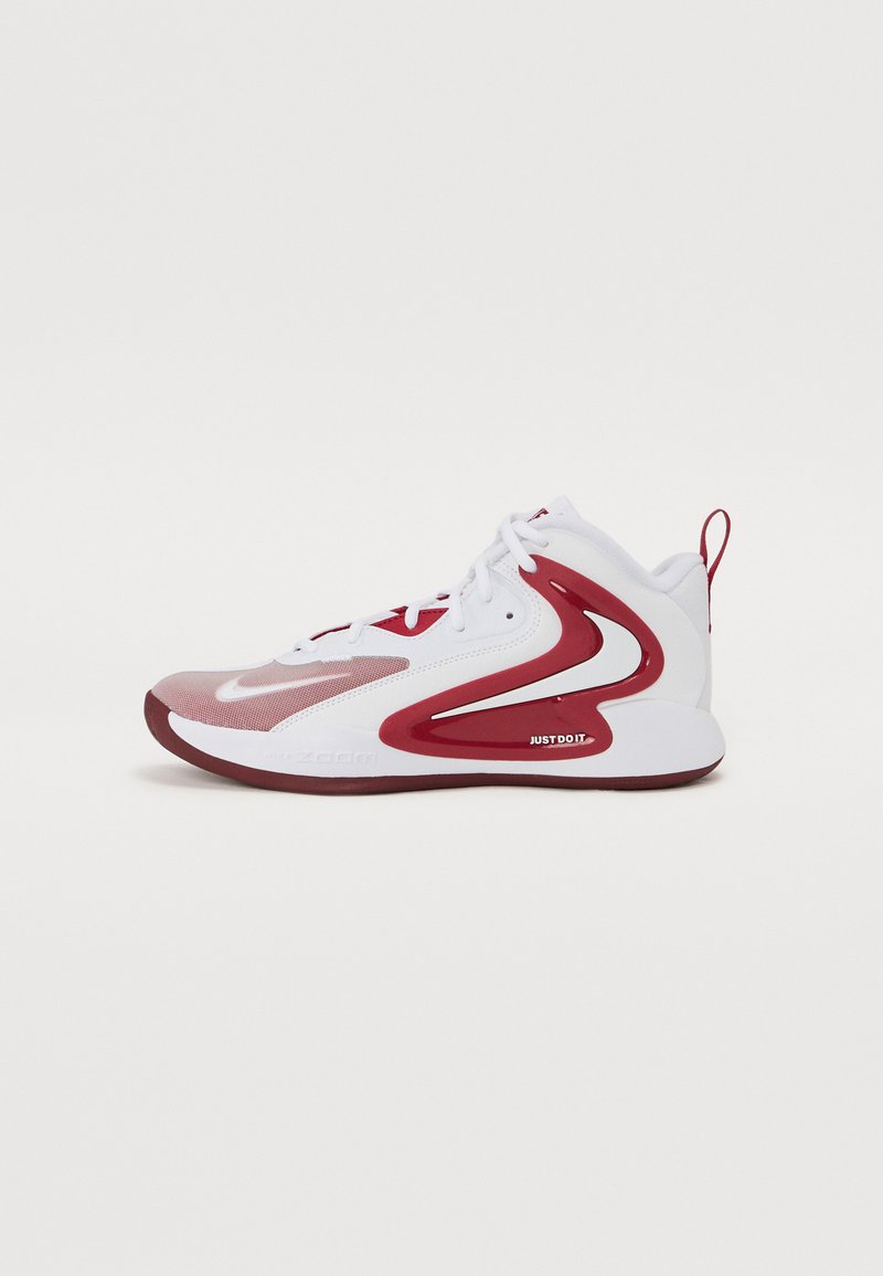 Baskets blanches de sport avec des accents rouges, dotées d'un dessus texturé, d'un bout circulaire et de détails sur le côté. Comprend le slogan "Just Do It".