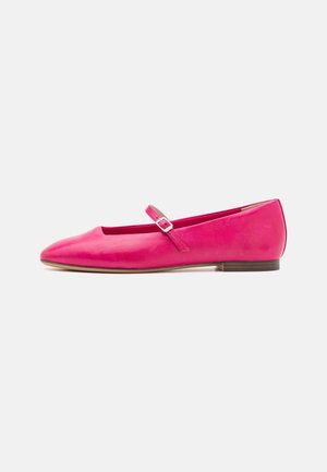 Chaussure Mary Jane plate en cuir rose avec bout pointu, bride à boucle argentée et petit talon marron sur fond blanc uni.