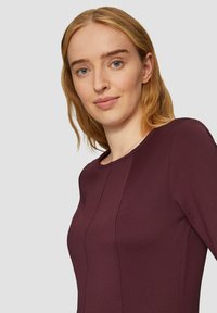 Bordo, długi rękaw, top z okrągłym dekoltem, żebrową strukturą i panelem. Ozdobiony eleganckimi przeszyciami.
