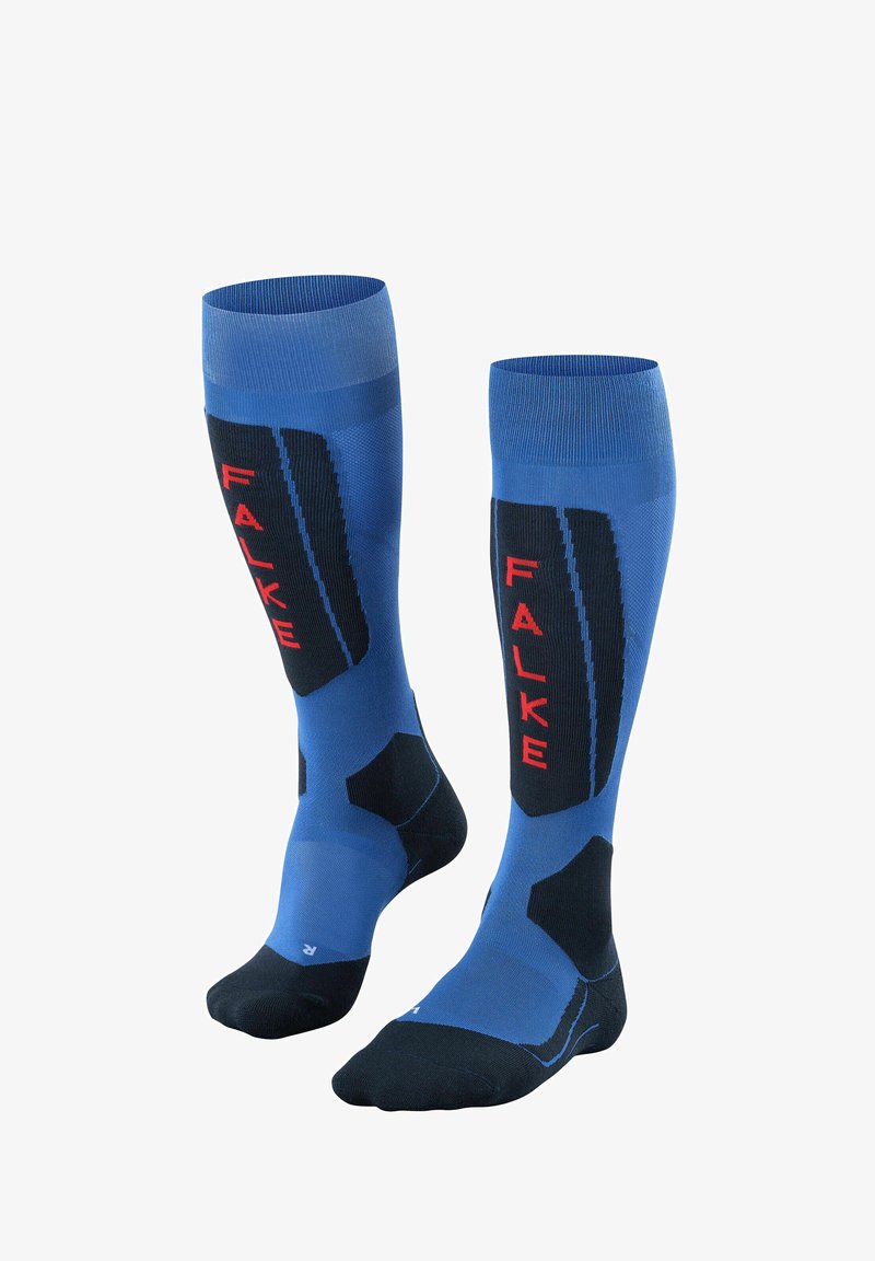 Calze blu al ginocchio con accenti neri, pannelli testurizzati e branding rosso "FALKE". Progettate per comfort e supporto durante l'uso atletico.
