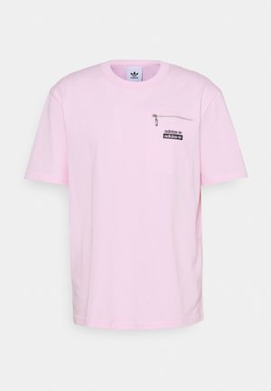 Vaaleanpunainen puuvillainen lyhythihainen t-paita, jossa on pyöreä pääntie, pieni vetoketjullinen rintatasku ja musta Adidas-logo.