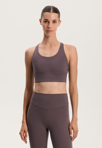 Ljubičasti atletski crop top s okruglim izrezom i širokim naramenicama. Napravljen od rastezljivog materijala s glatkom teksturom i minimalnim detaljima šavova.