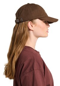 Brown cotton baseball cap with a curved visor and a strap-back closure. Features stitching accents and ventilation holes on the crown.
