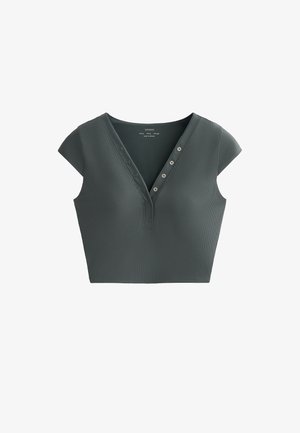 Top corto verde scuro realizzato in tessuto a coste, caratterizzato da un collo a V, maniche corte e sei bottoni decorativi sul davanti.