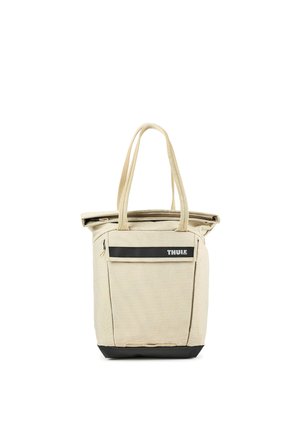 Bolso tote beige con base negra, dos asas largas, bolsillo frontal con cremallera y logo de Thule en una franja negra.