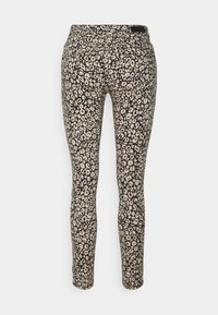 Pantaloni neri aderenti con un motivo floreale beige, caratterizzati da una texture liscia e una vita a media altezza. Nessun hardware o dettaglio visibile.