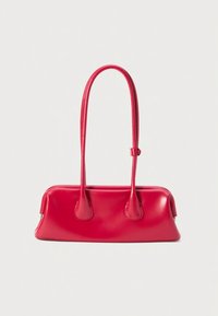 Mala de mão em pele vermelha com duas alças longas, acabamento liso e brilhante, e fundo arredondado. Apresenta um design minimalista e fecho seguro.