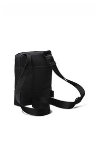 Bolso bandolera negro hecho de tela texturizada, con forma rectangular, correa ajustable y un diseño minimalista sin herrajes visibles.