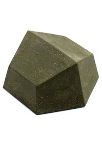 Zielony betonowy obiekt o geometrycznym kształcie, z wieloma płaskimi powierzchniami i teksturowanym wykończeniem, przypominający oszlifowany kamień.