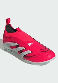 Scarpa da calcio rosa con tomaia sintetica testurizzata, caratterizzata da strisce diagonali bianche e un design elegante e a profilo basso. Tacchetti trasparenti sulla suola.