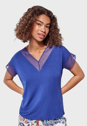 Top de manga corta en azul royal con diseño de escote en V, que presenta detalles de malla transparente y texturizados en las mangas. Acabado de tela suave.