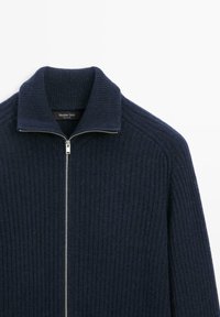 Granatowy sweter z prążkowanego dzianiny z kołnierzem typu funnel, z zamkiem błyskawicznym z przodu i miękką fakturą. Etykieta wewnętrzna głosi "Massimo Dutti".