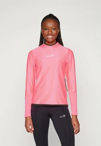 Hele pikkusega spordisärk eredat roosat värvi, millel on kõrge kaelus ja kerge, tekstuuriga kangas. Logo on diskreetselt paigutatud rinna piirkonda.