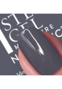 Donkergrijze nagellak tentoongesteld op een manicured vinger. De nagellak heeft een glanzende afwerking en weerkaatst licht, waardoor de gladde textuur zichtbaar wordt.