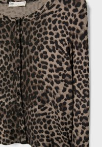 Rebrast cardigan v bež barvi s črnim vzorcem leoparda, ki ima okroglo ovratnico in pet črnih gumbov spredaj.