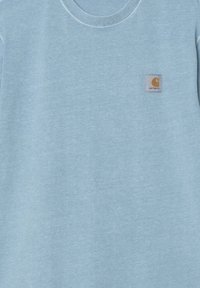Sudadera de cuello redondo azul claro hecha de un material suave. Presenta un pequeño parche de logo cuadrado en la esquina superior izquierda.