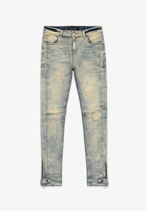 Lichtgewassen skinny jeans met voorzakken, ritssluiting en drukknopdetails bij de enkelboorden, en een vervaagde, versleten textuur over het hele oppervlak.
