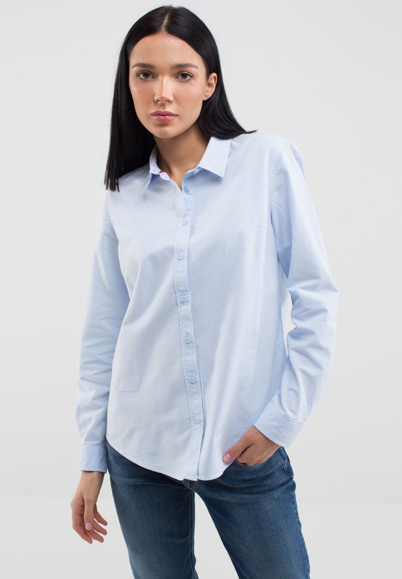 Camicia azzurra a maniche lunghe con bottoni, realizzata in cotone, con colletto alla francese, colletto appuntito e vestibilità rilassata con una sottile texture.
