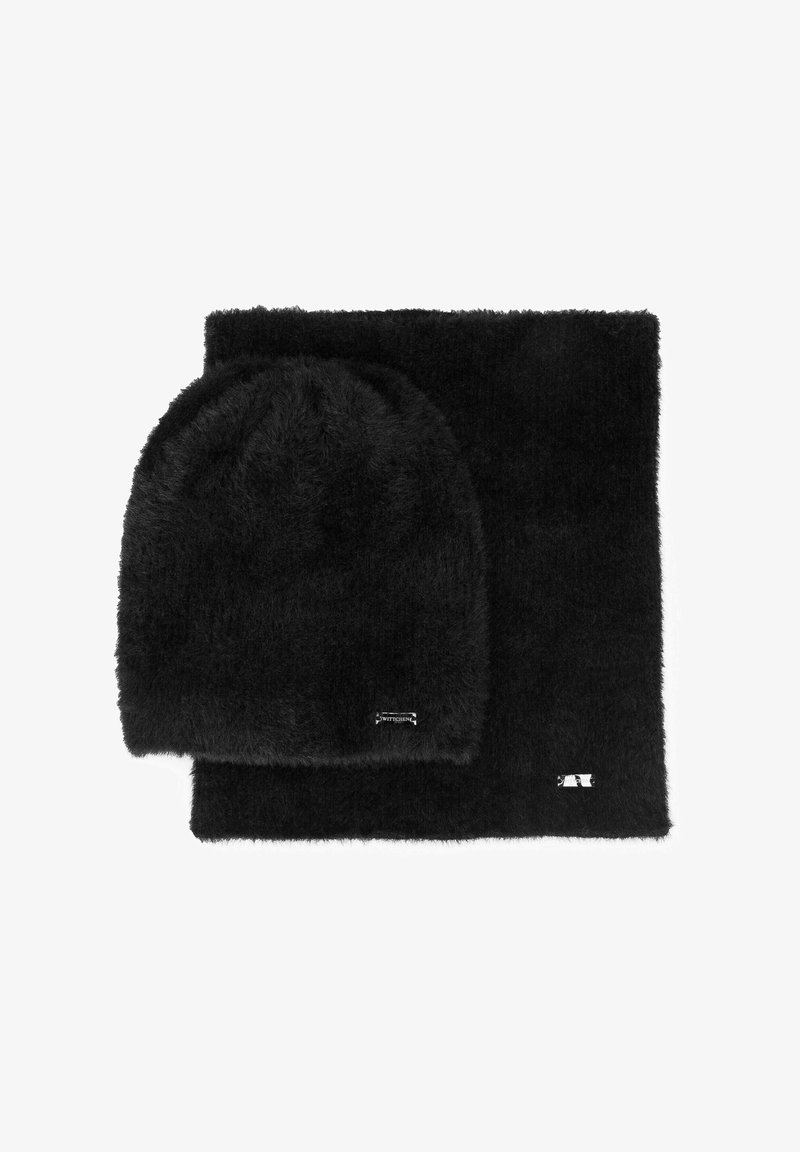 Ensemble bonnet noir duveteux et écharpe assortie, fabriqués en matériau doux. Les deux articles présentent un branding minimal avec des accents argentés.