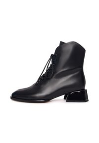 Zwarte leren enkelboots met een spitse neus, voorzien van voorste vetersluiting en een onderscheidende sculpturale blokhak. Gladde textuur en slanke silhouet.