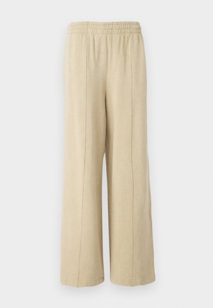 Bežové nohavice s širokými nohavicami a elastickým pásom, s viditeľnými bočnými švami. Vyrobené z mäkkej tkaniny s hladkým povrchom.