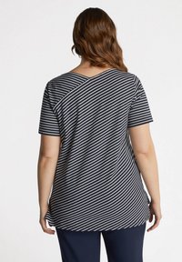 Camiseta a rayas en navy y blanco con mangas cortas y un diseño de costura diagonal único en la parte trasera, fabricada con un material suave y ligero.