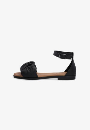 Sort lædersandal med en knyttet front, justerbar ankelrem og flad sål, med en glat overflade og minimalt hardware.