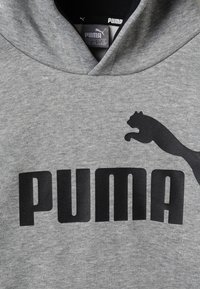 Grå bomullshuvtröja med en stor svart "PUMA"-logotyp och en kattens silhuett i språng. Mjuk textur med en klassisk huva.