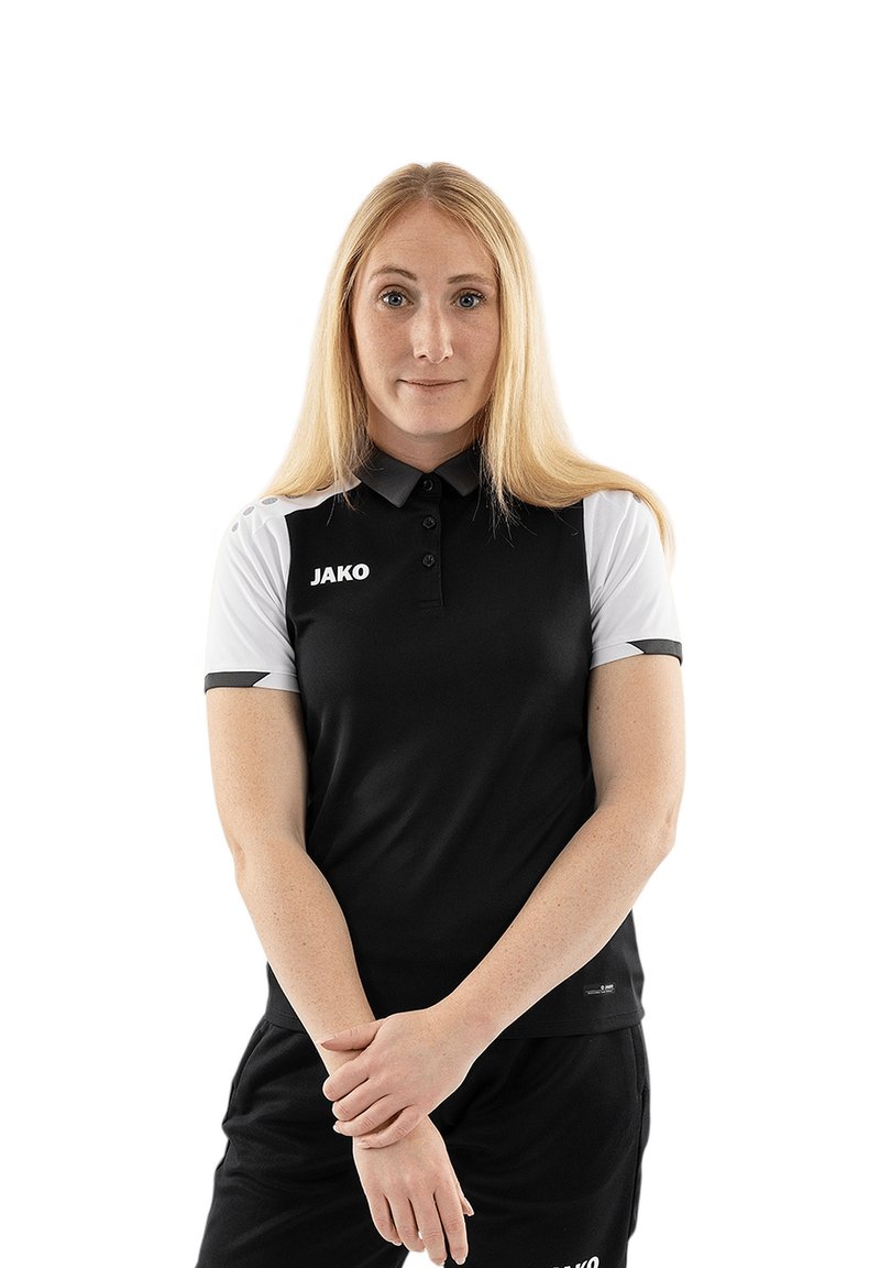 Schwarz-weißer Polo-Shirt mit kurzen Ärmeln, ausgestattet mit einem Kragen und dem Logo "JAKO" auf der Brust. Das Material wirkt glatt und sportlich.