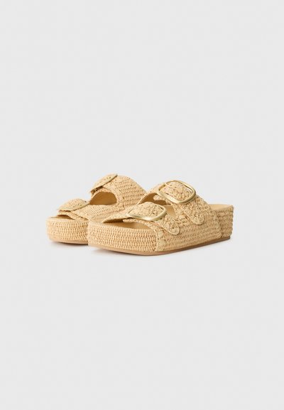 Tongs tissées beige avec deux sangles réglables, surface texturée et semelle épaisse, ornées d'accents en métal doré.