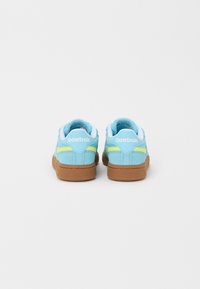 Sapatilhas Reebok com um cabedal em camurça azul claro, detalhes em branco, design de faixa amarela e sola de borracha texturizada em castanho.