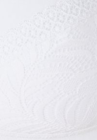 Sujetador blanco con un diseño de encaje texturizado a lo largo del borde superior, con tela suave debajo y sutiles detalles en el patrón de encaje.