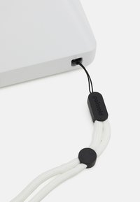 Polaroid camera strap in white braided material with a black rubber attachment, featuring a rounded clip and integrated cord for securing to the device.